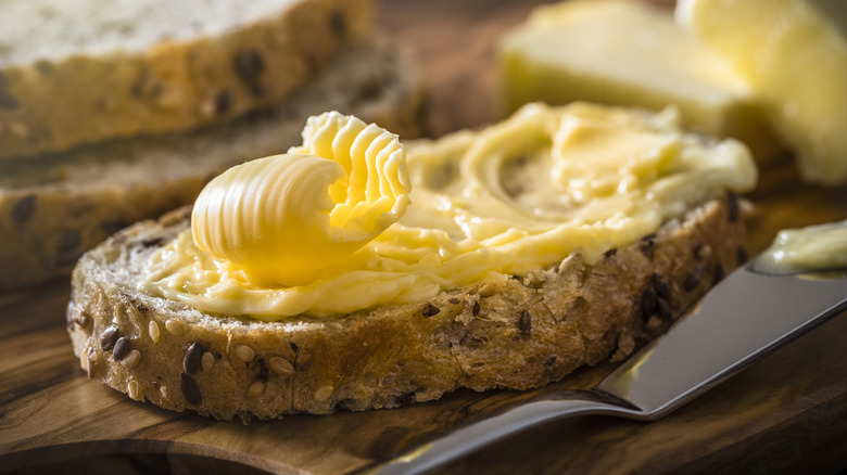 Butter on a slice of seeded bread