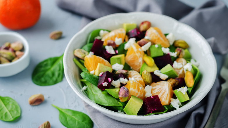 Spinach salad with oranges, feta cheese, beets, pistachios, and avocado
