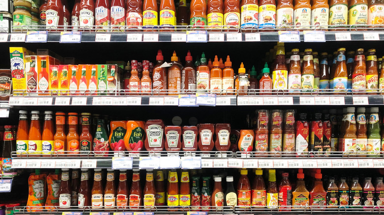 Various condiment bottles on the grocery store shelf