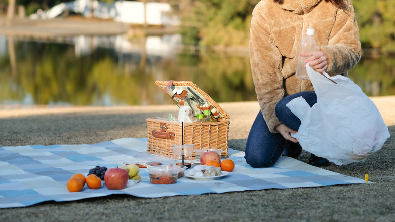 A woman cleans up after a picnic