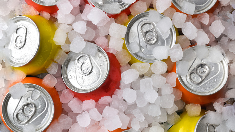 Canned drinks covered in small ice cubes