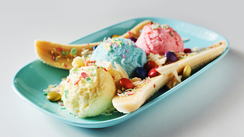 A banana split made with pink, blue, and white ice cream.