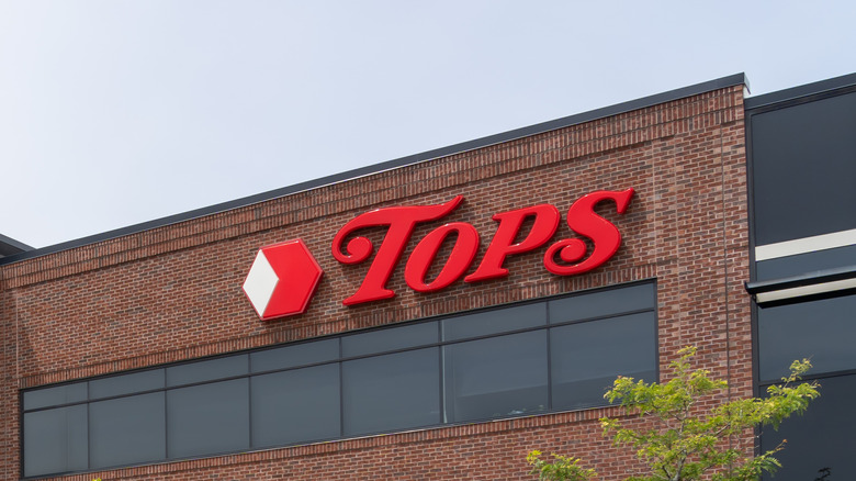 Tops sign affixed to office building with brick exterior