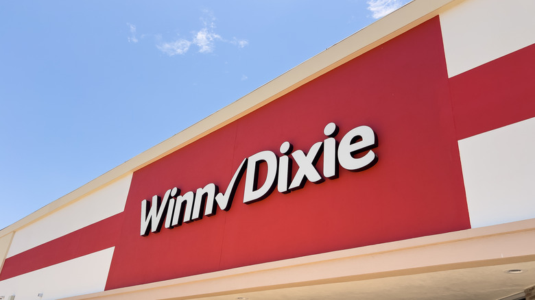 Winn-Dixie signage in white letters on a red backdrop beneath a blue sky