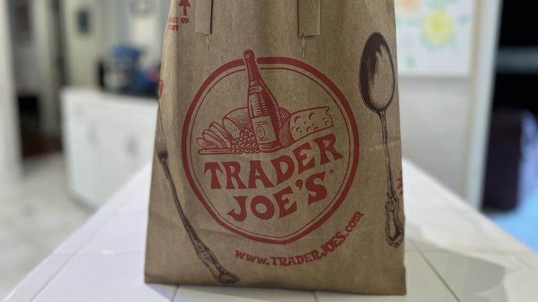 A Trader Joe's grocery bag sits on a kitchen counter.