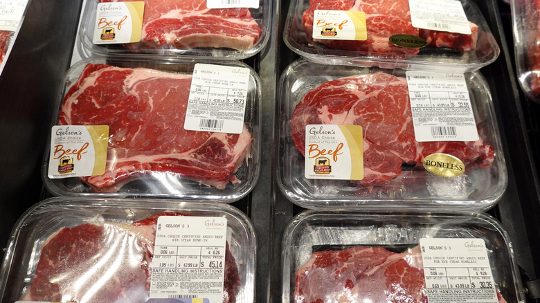 Steaks are displayed in a grocery store cold case