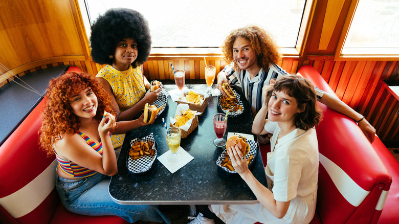 Group of friends eating at a vintage fast food restaurant