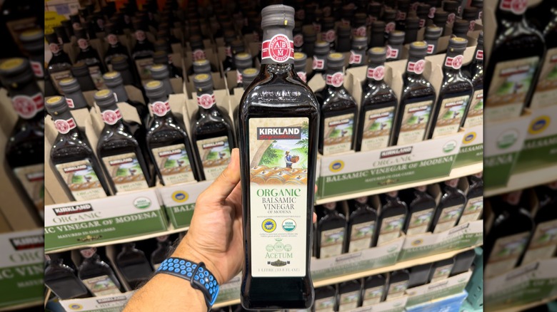 hand holding a bottle of Kirkland Signature balsamic vinegar in costco