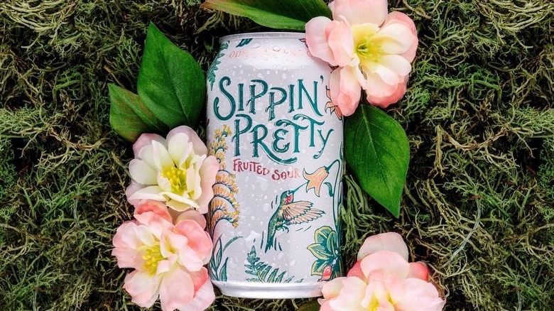 A can of Sippin Pretty alongside some pretty flowers.