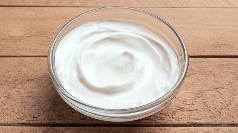 A bowl of Greek yogurt on a wooden surface