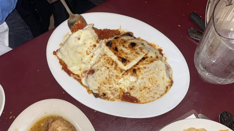 Veal parmigiana is served on a white plate.