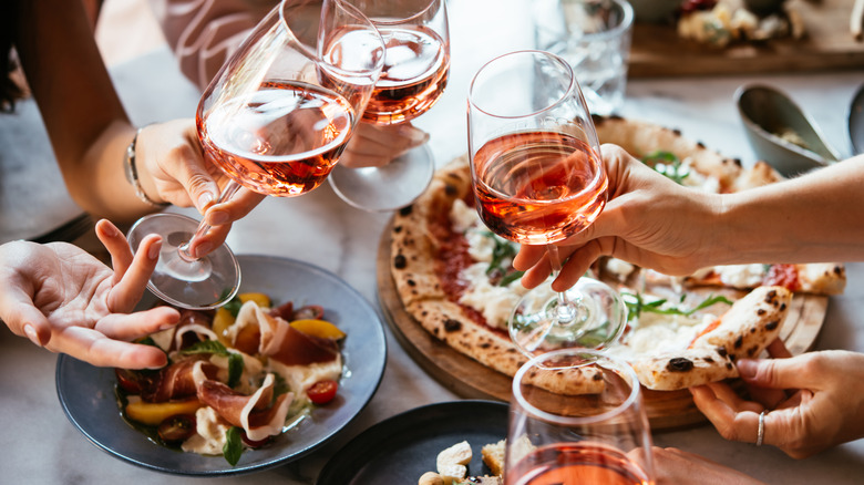 Friends toast with Italian food.