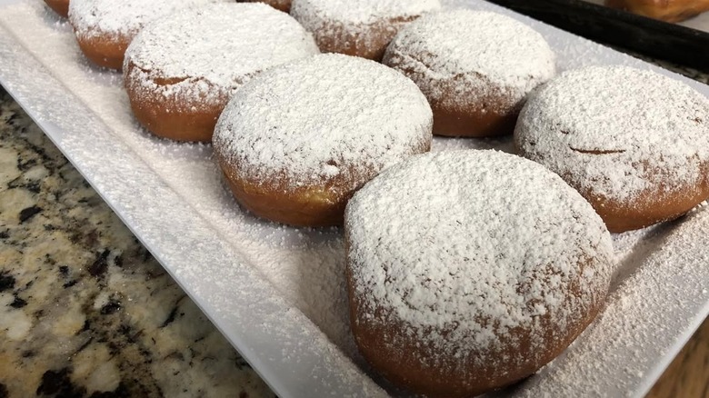 A tray of seasonal raspberry lemonade donuts dusted with powdered sugar