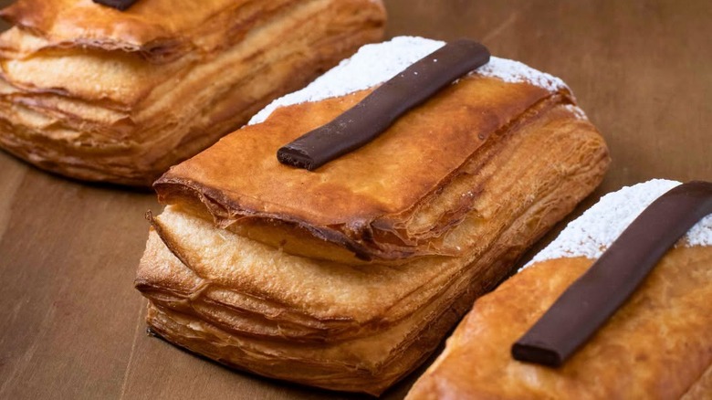 Chocolate Banana Cream Danishes displayed in a row on a wooden surface