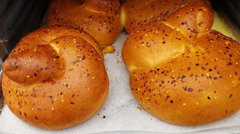 Four of Stella's famous hot and spicy cheese bread loaves sitting on wax paper, fresh from the oven