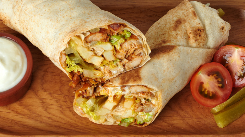 Chicken shawarma wrap with tomatoes, pickles, and yogurt