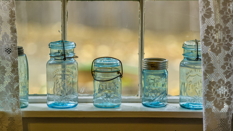 Collection of blue tinted jars on a window sill