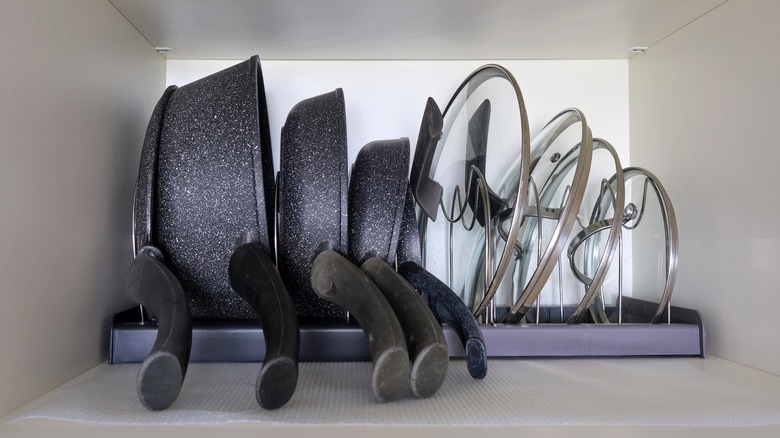 Pans and lids organizing in a cabinet