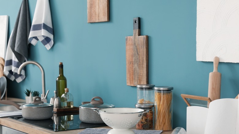 Cutting boards hanging on a blue kitchen wall