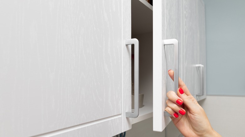 Hand opening up kitchen cabinet doors