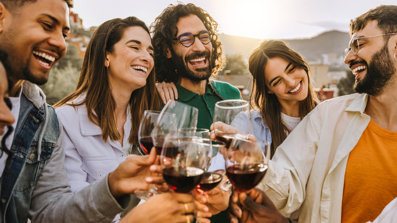 A group of friends smiling holding drinks
