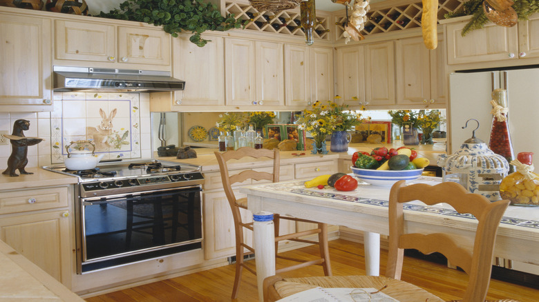 Kitchen with baskets and plants placed atop cabinets