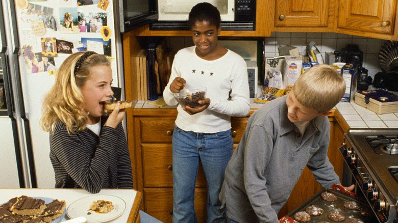 A group of children in a '90s kitchen making cookies