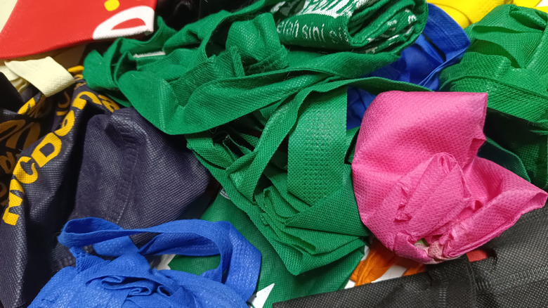 A bunch of reusable shopping bags in a pile