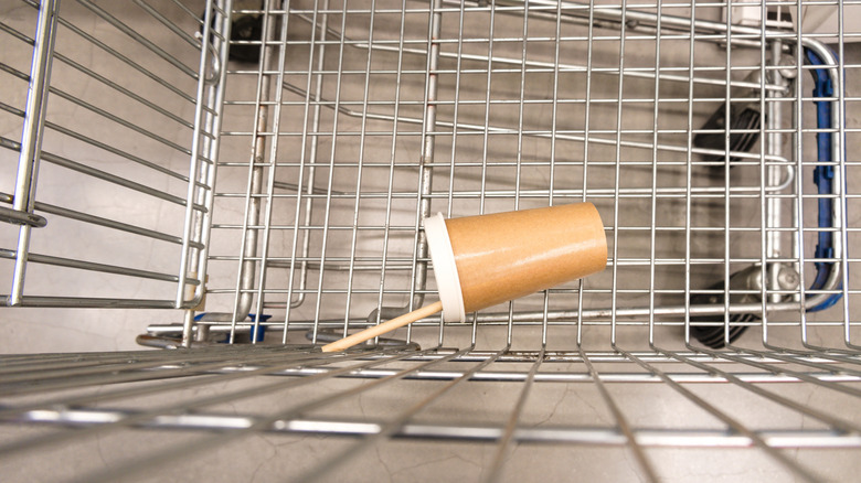 A disposable coffee cup left in a grocery cart