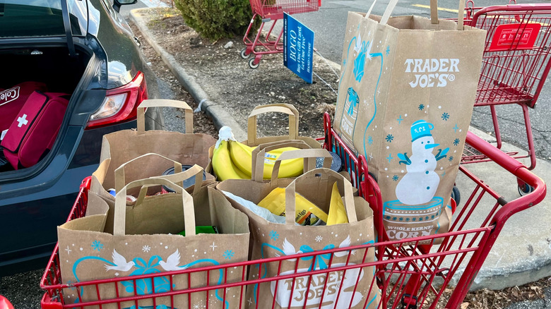 A cart filled with Trader Joe's groceries in shopping bags