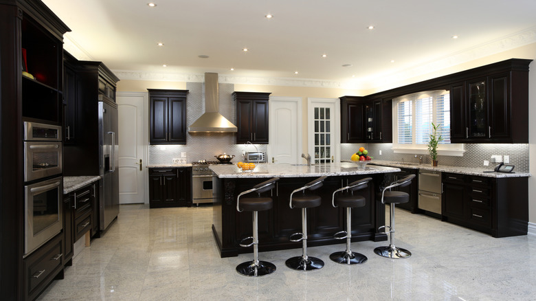 Kitchen with a white-gray stone floor and black cabinets