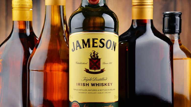 Bottle of Jameson sits prominently on a shelf with other unnamed whiskeys