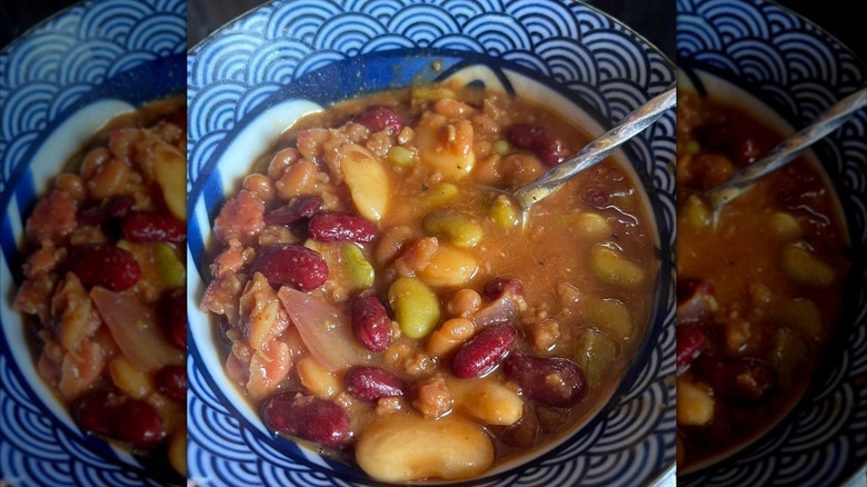 Calico beans in a bowl with a spoon.