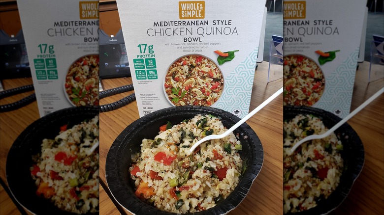 Aldi's Mediterranean-style chicken quinoa bowl sits in front of its packaging on a desk