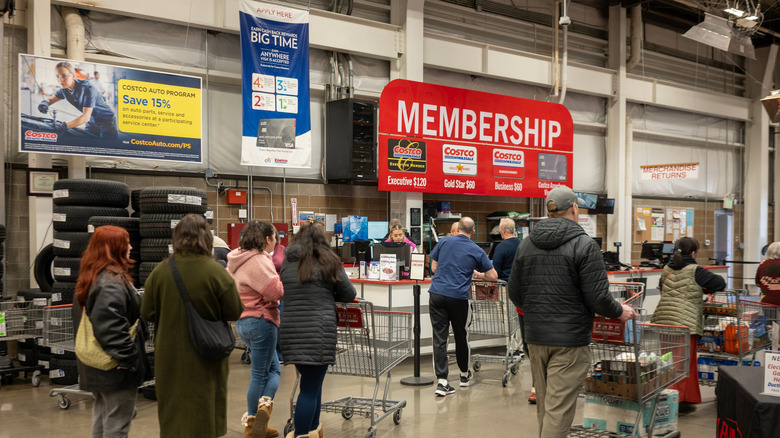 People lined up at a Costco membership counter.