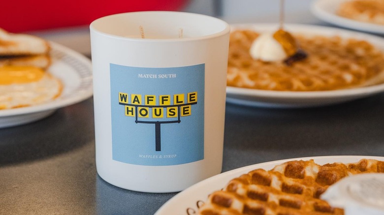 A branded Waffle House cup of maple syrup surrounded by waffles