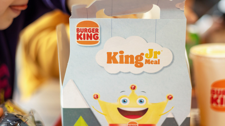 A child open a Burger King King Jr. Meal.