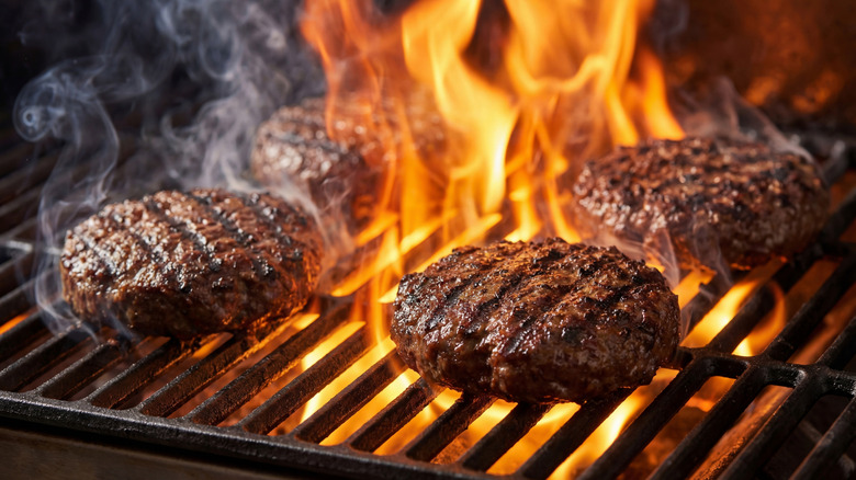burger patties cooking on a grill