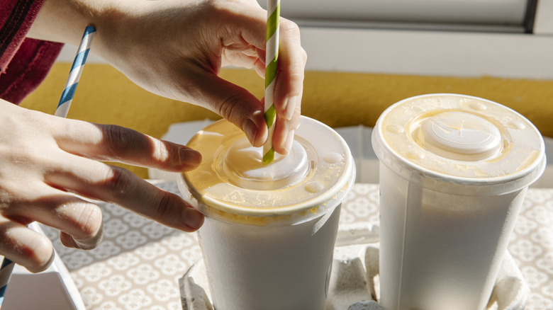 Person grabbing milkshakes