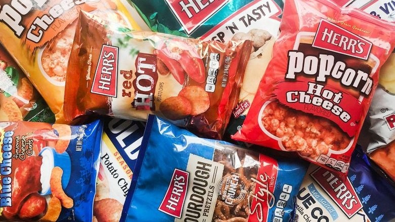 Assorted bags of Herr's chips including hot cheese and sourdough pretzels