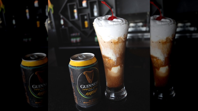 An ice cream float next to a Guinness beer can