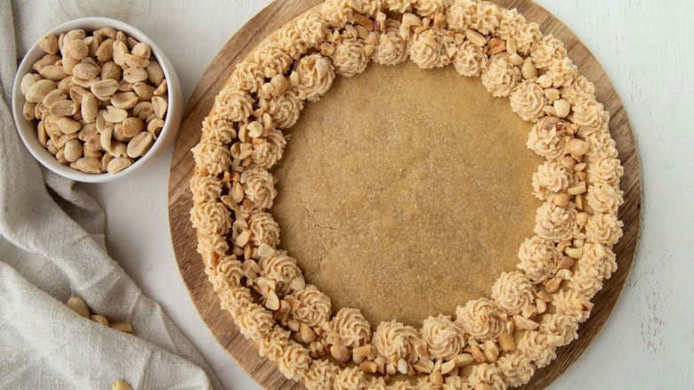 frosted peanut butter cookie cake and bowl with peanuts