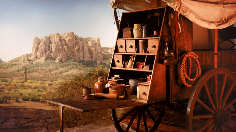 A chuck wagon, loaded with food and cooking tools, in the desert.