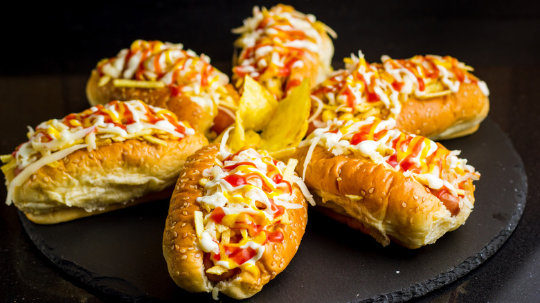 A plate of Venezuelan-style hot dogs topped with crispy potato sticks