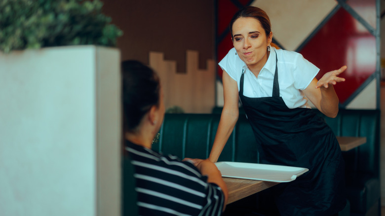 A frustrated server in front of a diner.