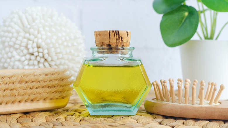 Bottle of olive oil with cleaning brush and supplies