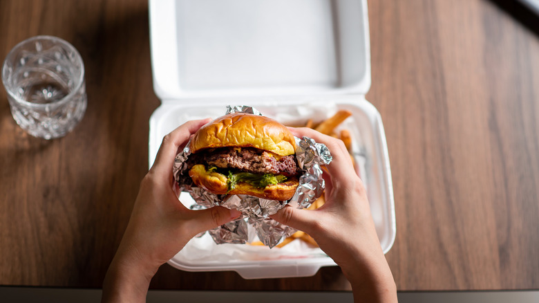Burger consumed out of takeout box.