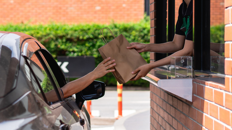 A drive-thru customer receives a bag of food.