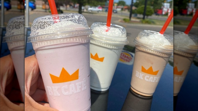 Three different BK Cafe milkshakes on a car hood.