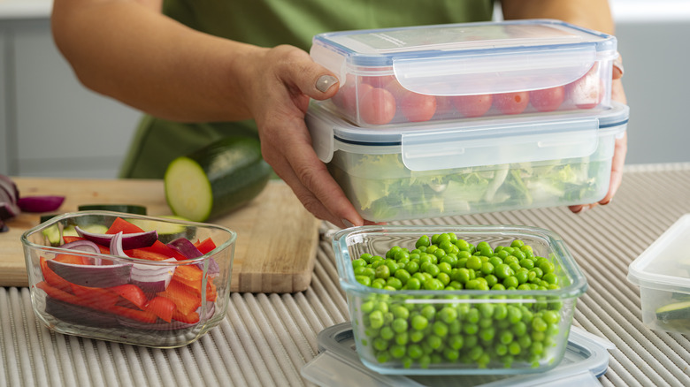 A person filling containers with fresh produce.